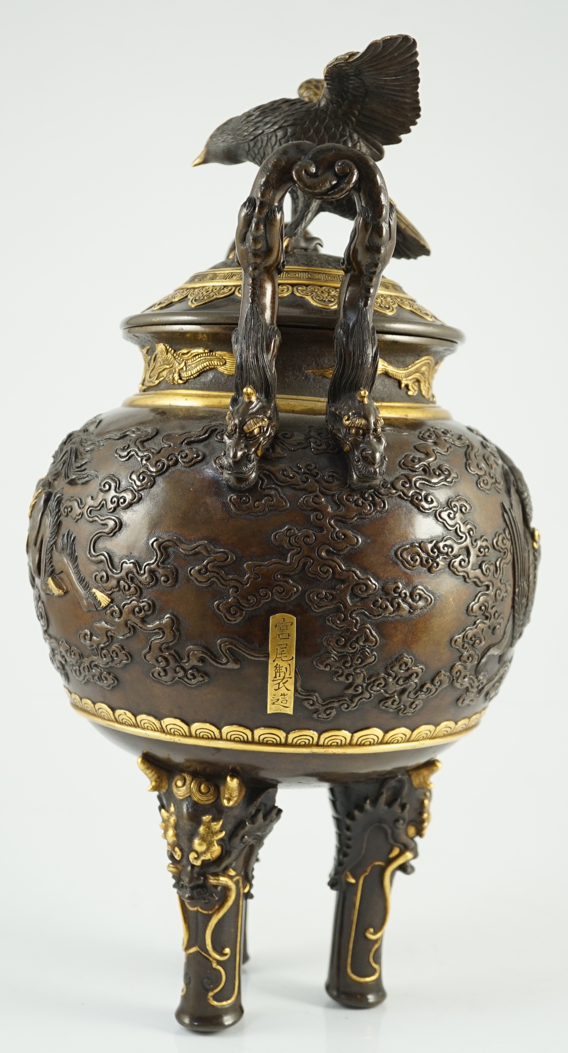 An impressive Japanese brown patinated and gilded bronze tripod koro and cover, by Miyao Eisuke, Meiji period, 42cm high, 23cm wide